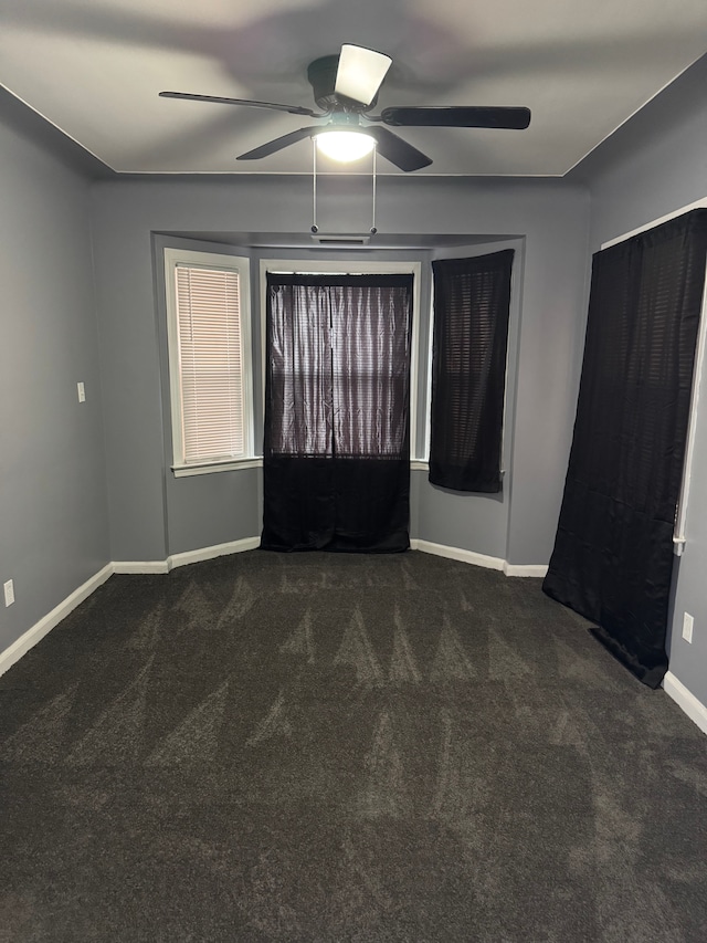 unfurnished bedroom featuring dark colored carpet and ceiling fan