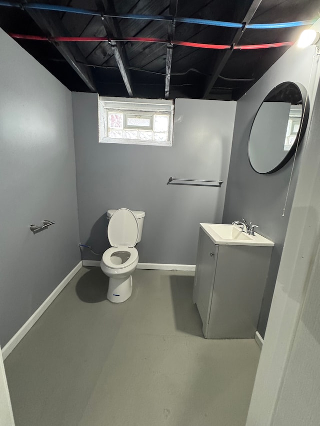 bathroom featuring vanity, concrete floors, and toilet