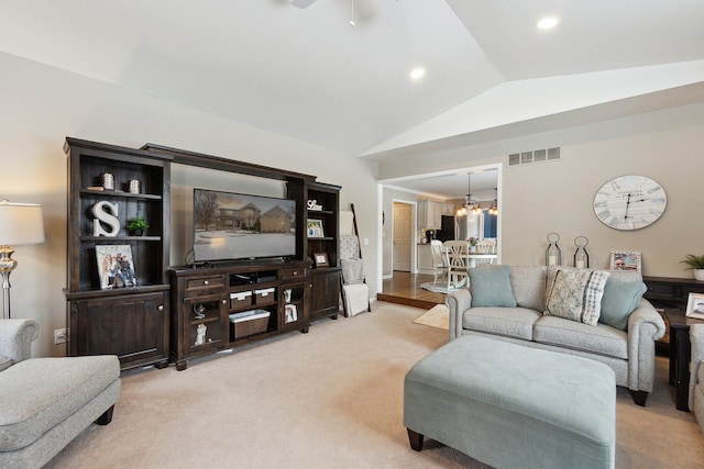 living room featuring vaulted ceiling, light carpet, and a chandelier