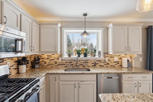 kitchen featuring pendant lighting, sink, appliances with stainless steel finishes, light stone counters, and white cabinets