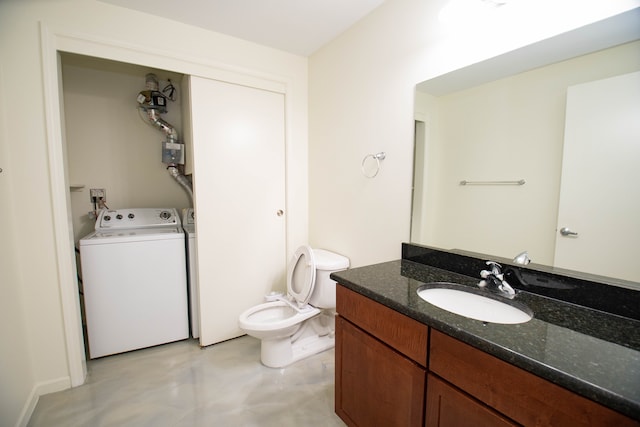 bathroom featuring toilet, washer / clothes dryer, concrete floors, and vanity