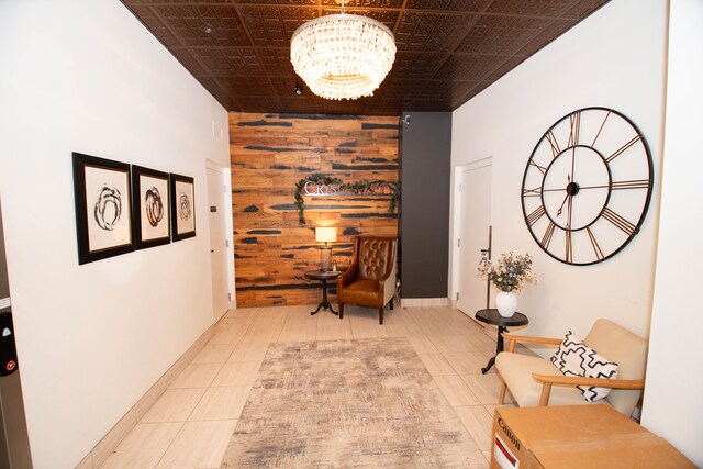 corridor featuring wood walls, tile patterned flooring, an accent wall, and an inviting chandelier