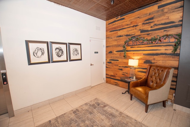 sitting room featuring an ornate ceiling, wooden walls, visible vents, and tile patterned floors