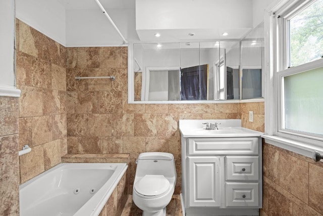 bathroom with vanity, toilet, a bathing tub, and tile walls