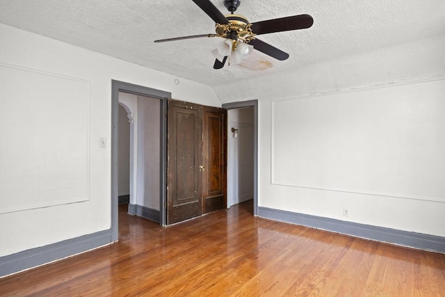 empty room featuring ceiling fan, hardwood / wood-style floors, and a textured ceiling