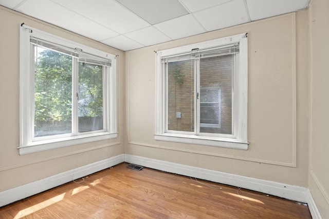 unfurnished room featuring a paneled ceiling and light hardwood / wood-style flooring