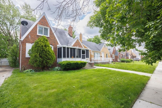 view of front of home featuring a sunroom and a front lawn