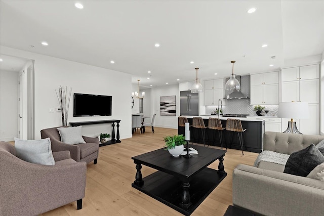 156 N Center St Unit 302, Northville, MI 48167 - living room featuring a notable chandelier, light hardwood / wood-style floors, and sink