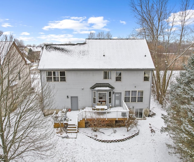 snow covered rear of property featuring a deck