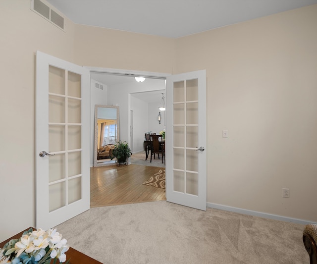 unfurnished room featuring french doors and carpet floors