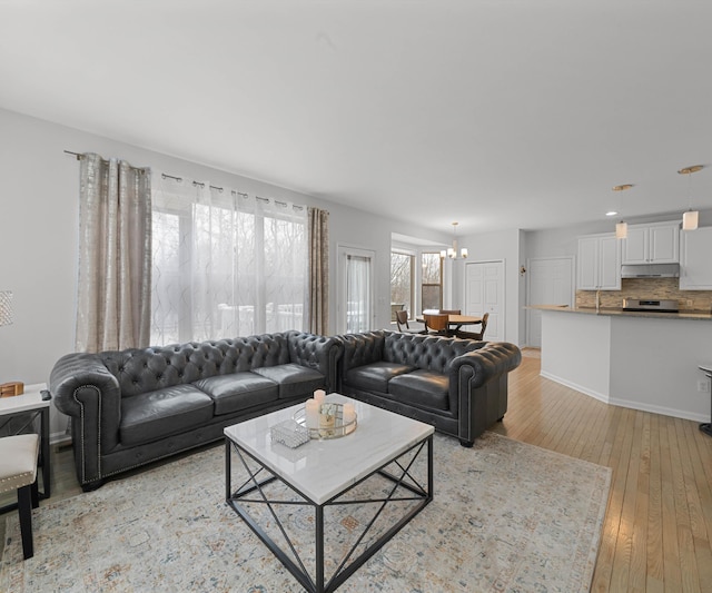 living room featuring a chandelier and light wood-type flooring