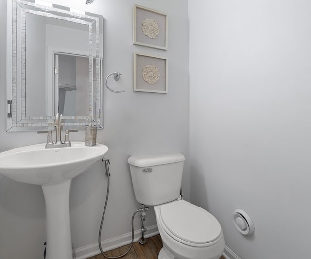 bathroom featuring hardwood / wood-style flooring, toilet, and sink