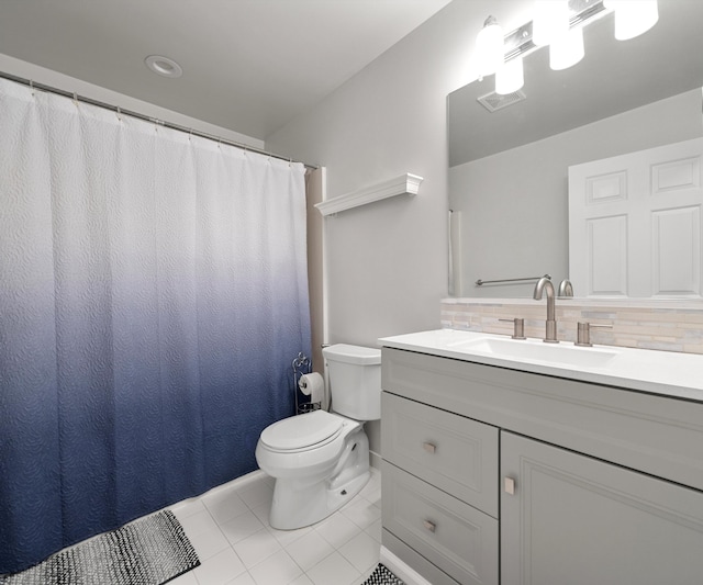 bathroom with vanity, toilet, tile patterned flooring, and decorative backsplash