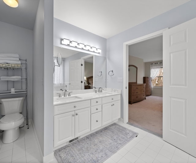 bathroom featuring vanity, tile patterned floors, and toilet