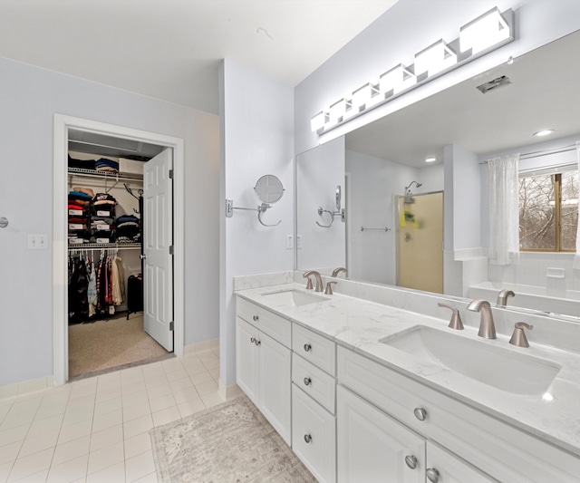 bathroom with tile patterned flooring, vanity, and a shower with shower door