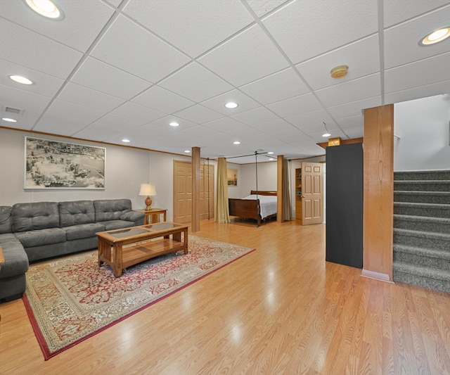 living room with a drop ceiling and light hardwood / wood-style floors