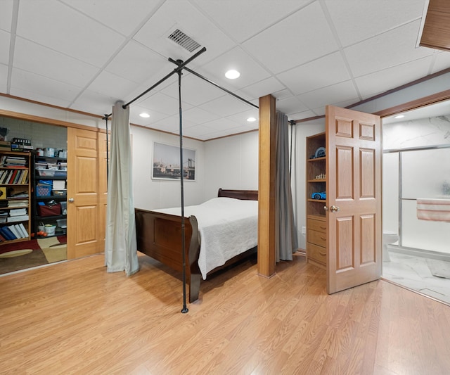 bedroom with a paneled ceiling and hardwood / wood-style floors