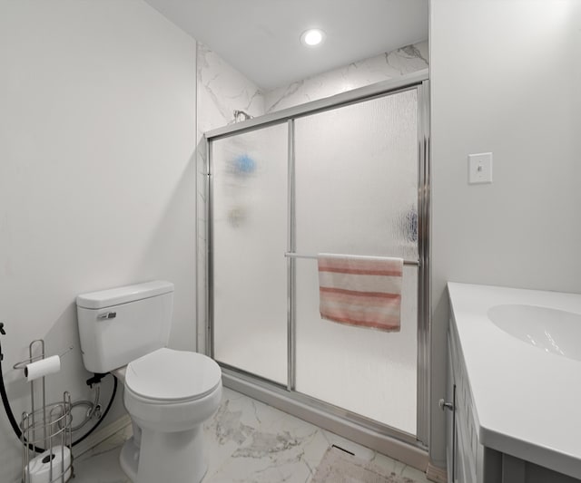 bathroom featuring an enclosed shower, vanity, and toilet