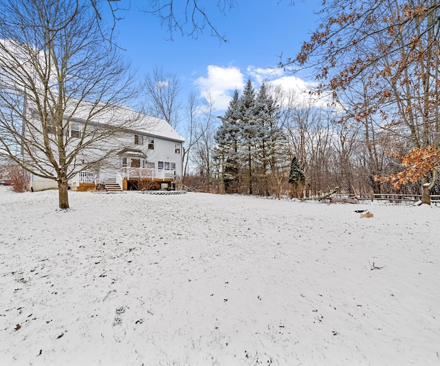 yard covered in snow with a deck