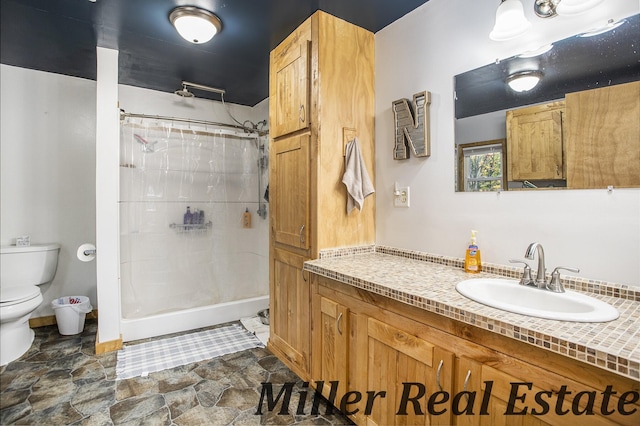 bathroom featuring a shower with curtain, vanity, and toilet