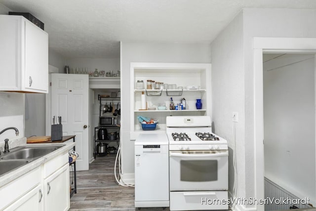 kitchen featuring white gas range, a textured ceiling, light hardwood / wood-style flooring, and white cabinets