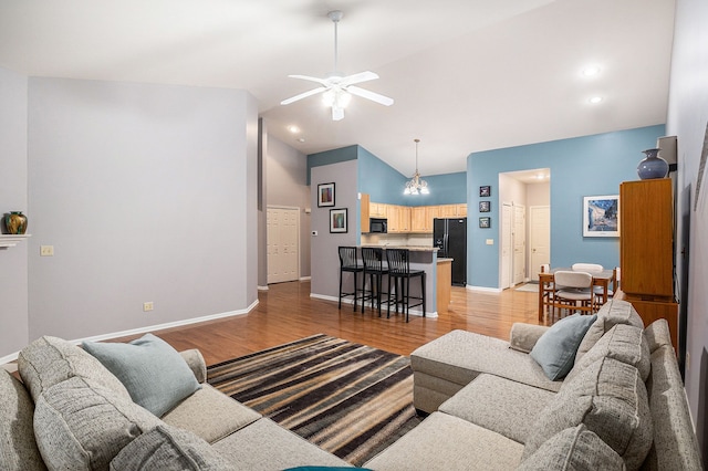 living room featuring high vaulted ceiling, ceiling fan, and light hardwood / wood-style flooring