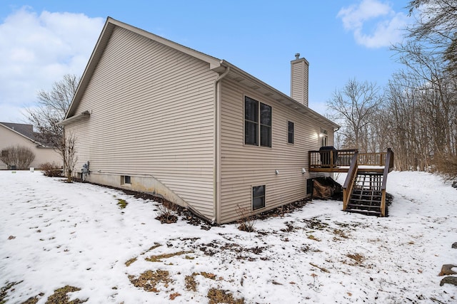 view of snow covered exterior with a wooden deck