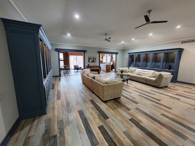 living room with hardwood / wood-style floors, crown molding, and ceiling fan