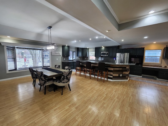 dining area featuring crown molding and light hardwood / wood-style floors