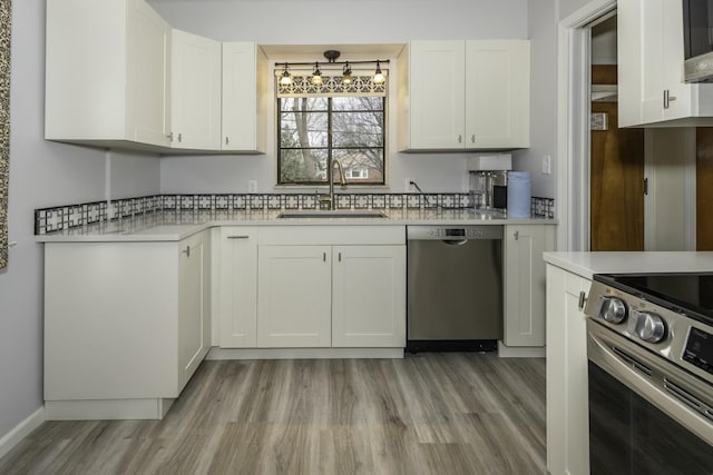 kitchen with appliances with stainless steel finishes, sink, light hardwood / wood-style flooring, and white cabinets