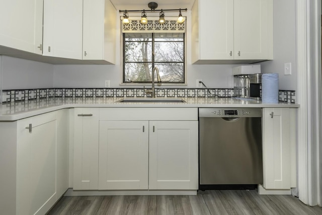 kitchen featuring sink, dishwasher, white cabinetry, dark hardwood / wood-style floors, and tasteful backsplash