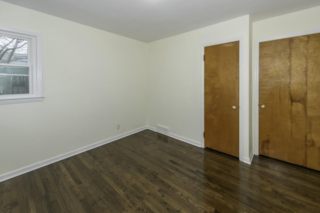 unfurnished bedroom with dark wood-type flooring