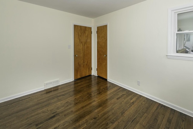 spare room featuring dark wood-type flooring