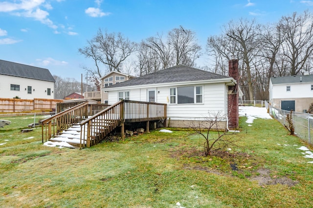 rear view of property with a wooden deck and a yard