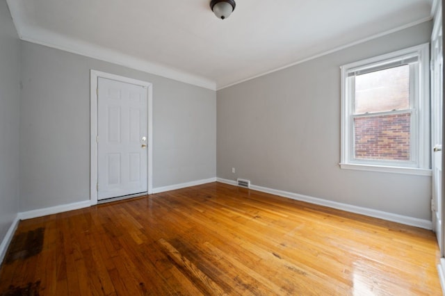 unfurnished room featuring crown molding and hardwood / wood-style flooring