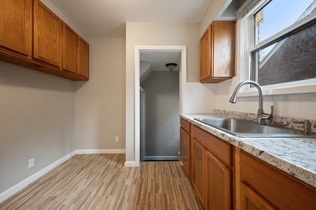 kitchen featuring sink, backsplash, and light hardwood / wood-style flooring