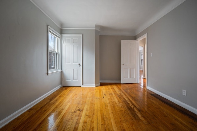 empty room featuring crown molding and light wood-type flooring