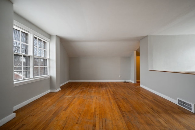 additional living space featuring lofted ceiling and wood-type flooring