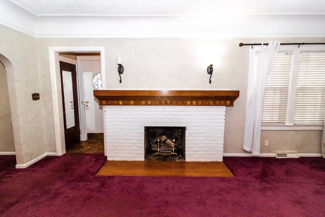 unfurnished living room featuring dark carpet and a brick fireplace