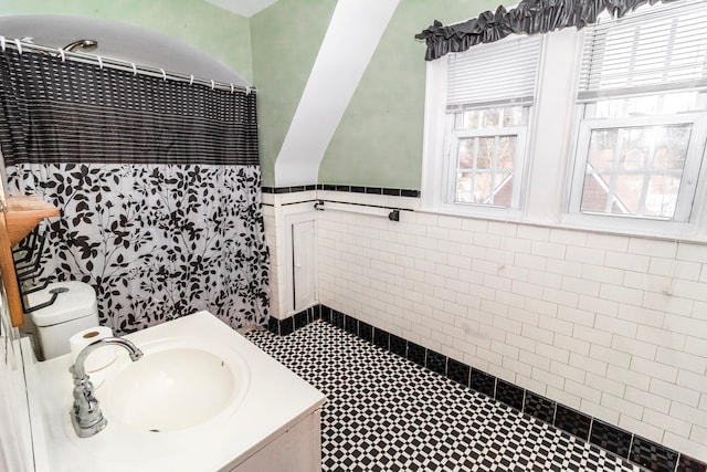 bathroom with a shower with curtain, vanity, toilet, and tile walls