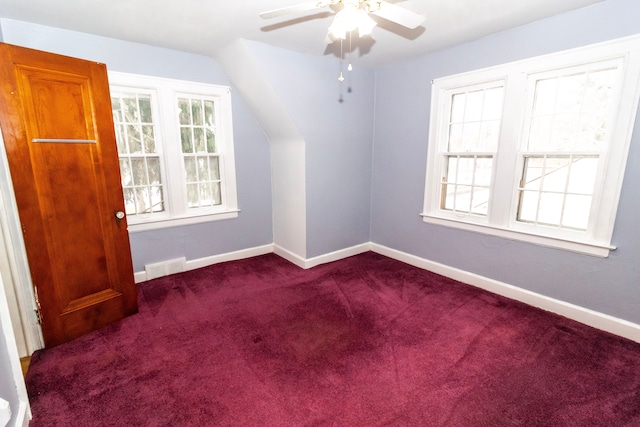 additional living space with ceiling fan, lofted ceiling, and dark colored carpet