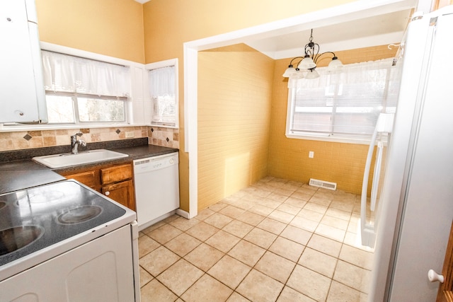 kitchen featuring decorative light fixtures, sink, white cabinets, light tile patterned floors, and white appliances