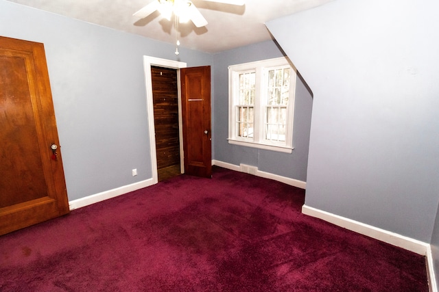 unfurnished bedroom featuring dark carpet and ceiling fan