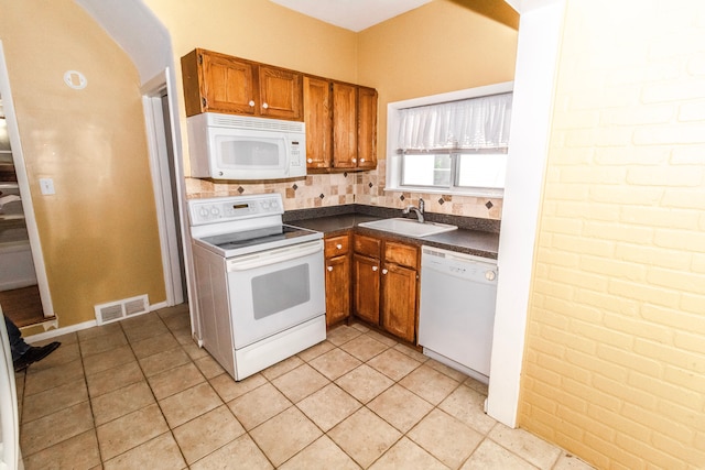 kitchen with white appliances, sink, and light tile patterned floors