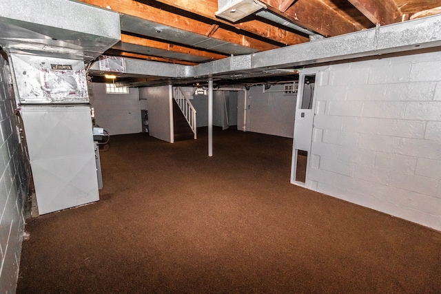 basement with heating unit and dark carpet