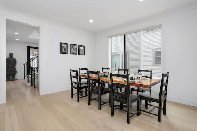 dining room featuring crown molding, plenty of natural light, and light hardwood / wood-style flooring