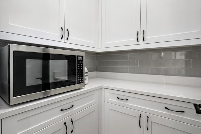 kitchen with white cabinetry and tasteful backsplash