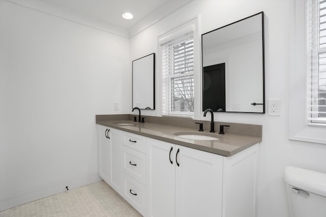 bathroom featuring vanity, ornamental molding, and toilet