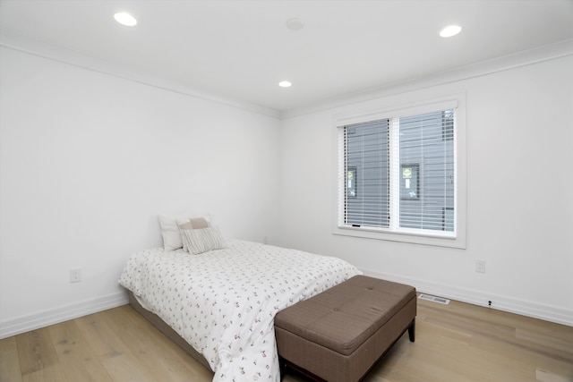 bedroom with crown molding and wood-type flooring