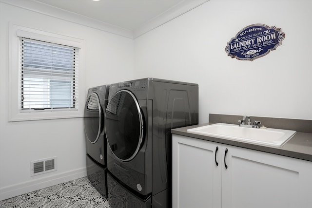 laundry area featuring ornamental molding, sink, washing machine and dryer, and light tile patterned floors